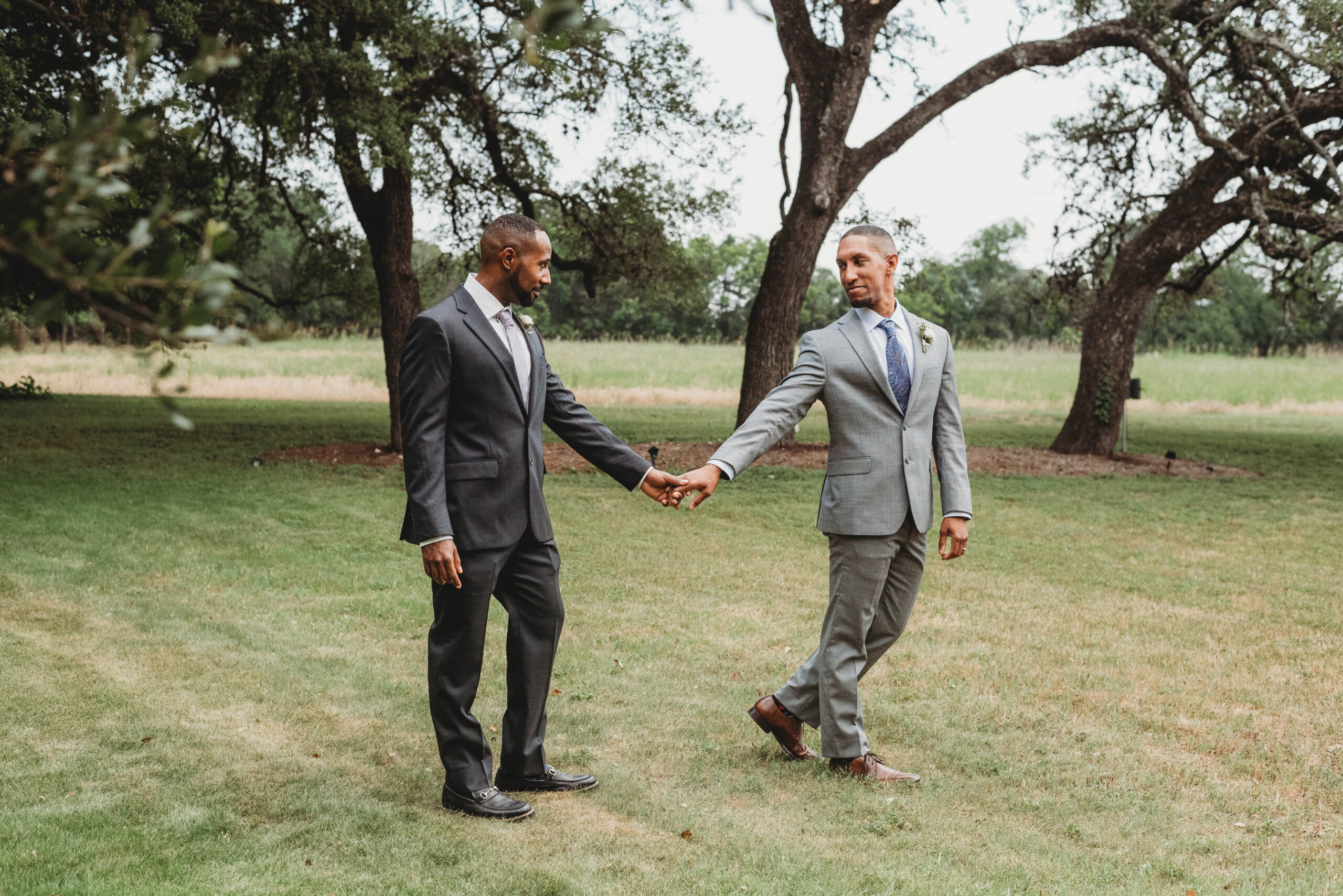 LGBTQ couple smile under the oak trees